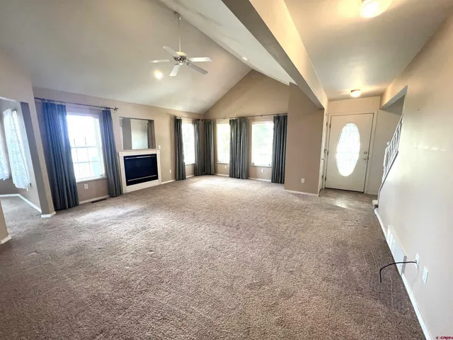 a view of a big room with windows and chandelier