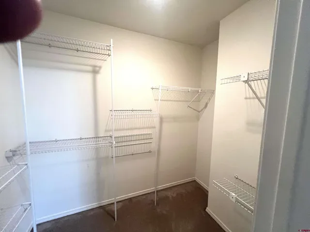 a view of walk in closet with empty racks