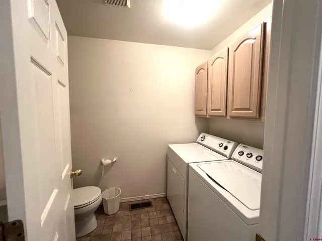 a bathroom with a sink toilet and window