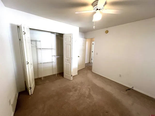 an empty room with closet and windows