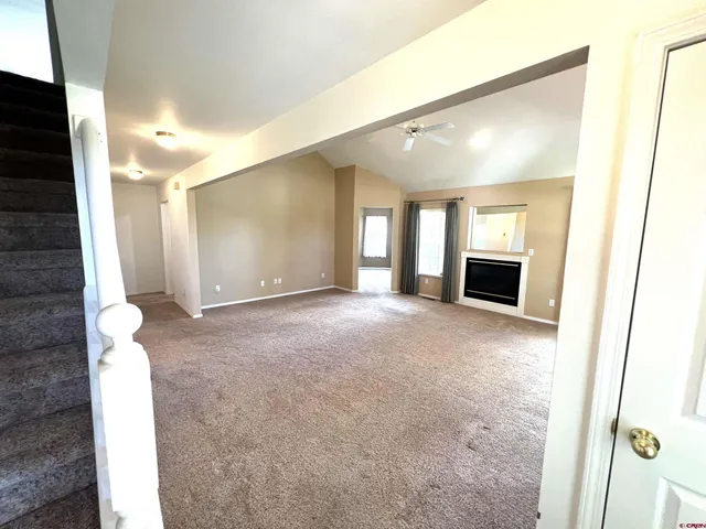 a view of a hallway with wooden floor and a bathroom