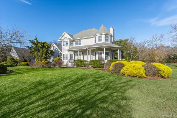 a front view of a house with a garden and trees