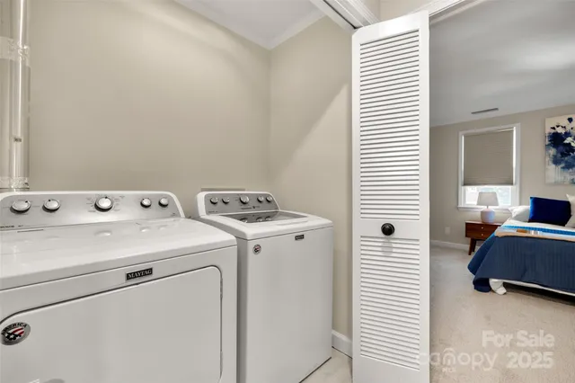a view of washer and dryer with bathroom in the background