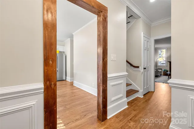a view of a hallway with wooden floor and staircase