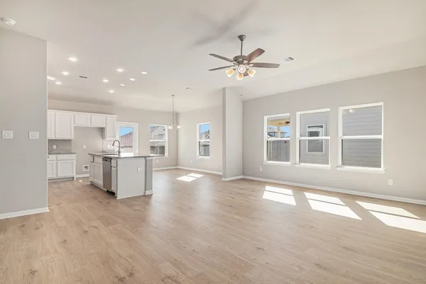 a large kitchen with granite countertop a large counter top a sink stainless steel appliances and cabinets