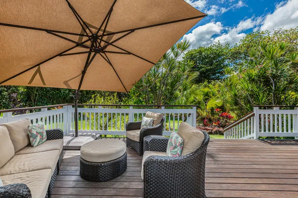 a view of deck with furniture and umbrella