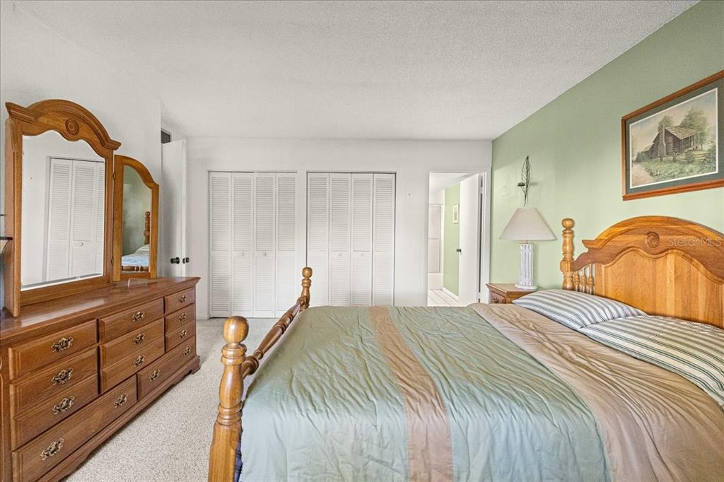 584 Fairways Circle, Unit A Ocala, FL 34472 - Photo 14 of 41 a bedroom with a bed a mirror on dresser and a window