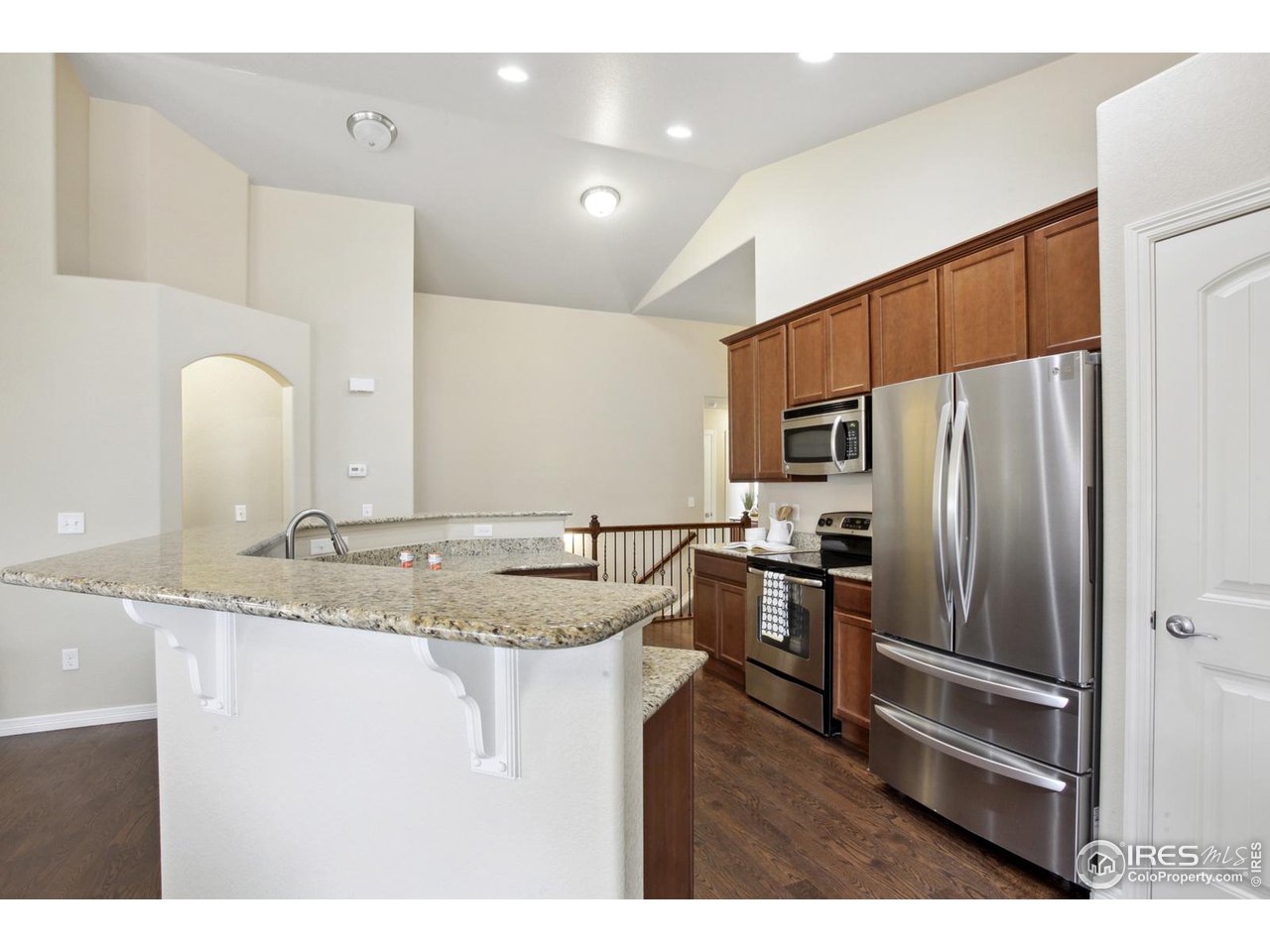 9018 Sandpiper Drive Frederick, CO 80504 - Photo 12 of 26 a kitchen with stainless steel appliances granite countertop a sink refrigerator and microwave