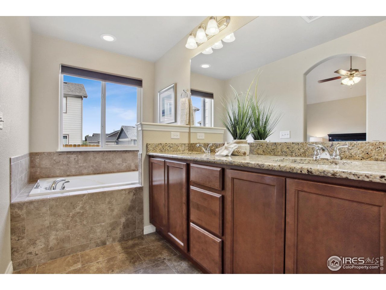 9018 Sandpiper Drive Frederick, CO 80504 - Photo 15 of 26 a bathroom with a granite countertop sink a large mirror and a