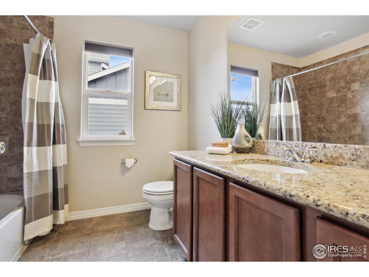 9018 Sandpiper Drive Frederick, CO 80504 - Photo 19 of 26 a bathroom with a granite countertop sink toilet and shower
