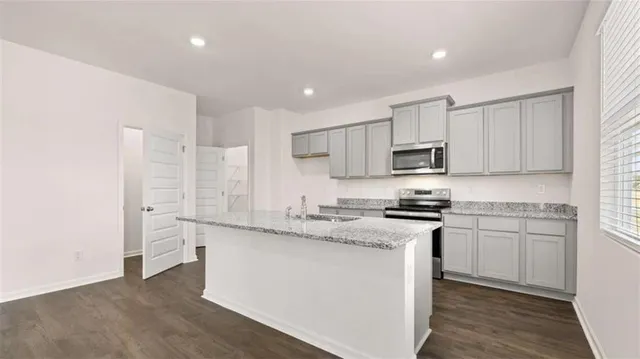 a kitchen with stainless steel appliances granite countertop a stove a sink and a refrigerator