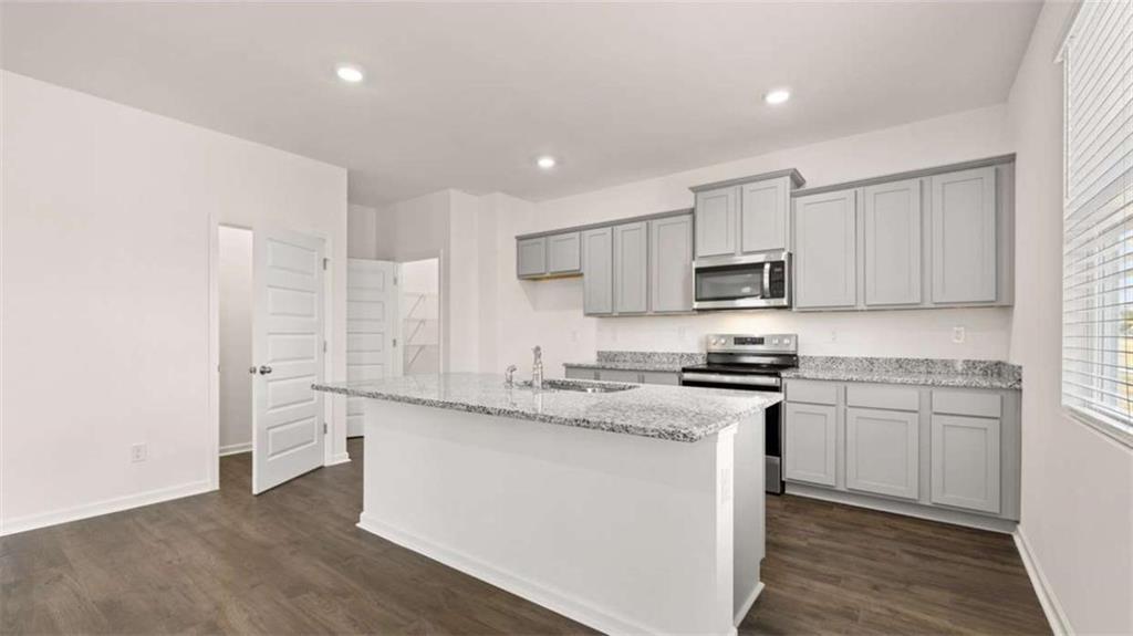 178 Aster Avenue Locust Grove, GA 30248 - Photo 12 of 36 a kitchen with stainless steel appliances granite countertop a stove a sink and a refrigerator
