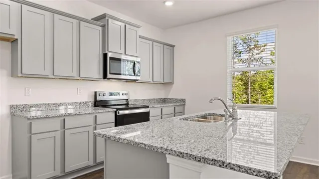 a kitchen with stainless steel appliances granite countertop a sink stove and cabinets