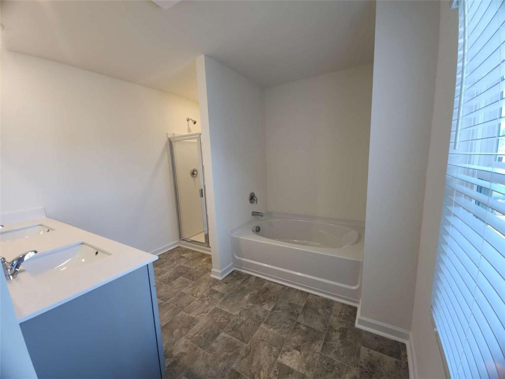 178 Aster Avenue Locust Grove, GA 30248 - Photo 23 of 36 a bathroom with a bathtub sink and a shower