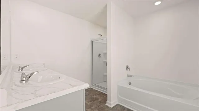 a bathroom with a tub sink vanity and a tub