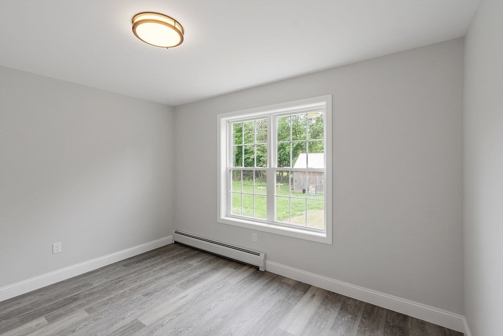 572 Pleasant Street Athol, MA 01331 - Photo 17 of 32 an empty room with wooden floor and windows