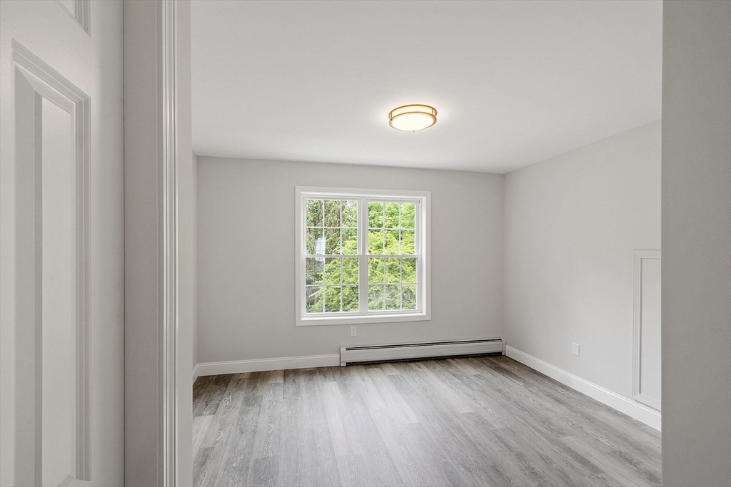 572 Pleasant Street Athol, MA 01331 - Photo 21 of 32 an empty room with wooden floor and window