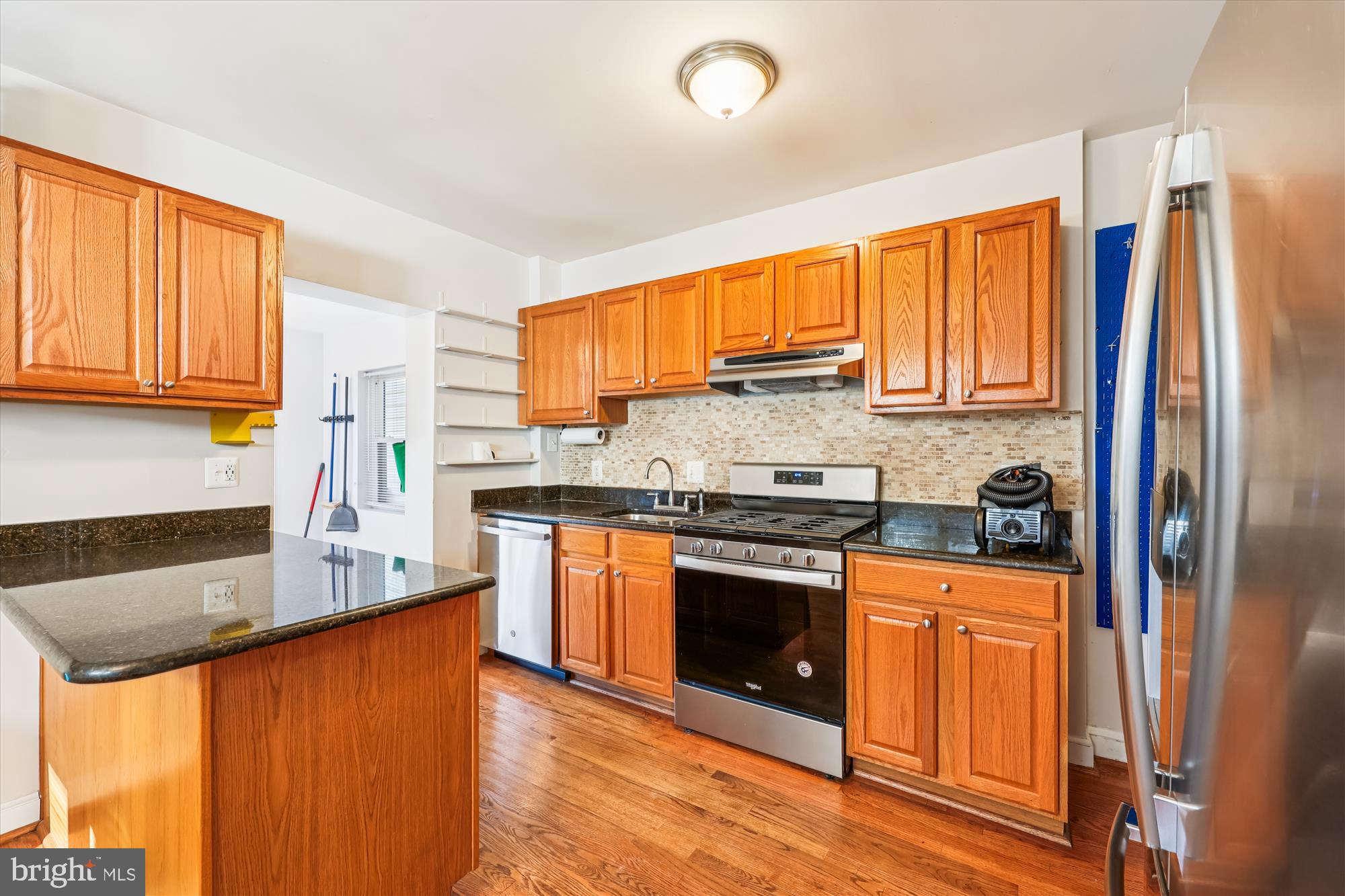 4808 Fort Totten Drive Northeast Washington, DC 20011 - Photo 6 of 30 a kitchen with stainless steel appliances granite countertop a refrigerator a sink dishwasher and wooden cabinets with wooden floor