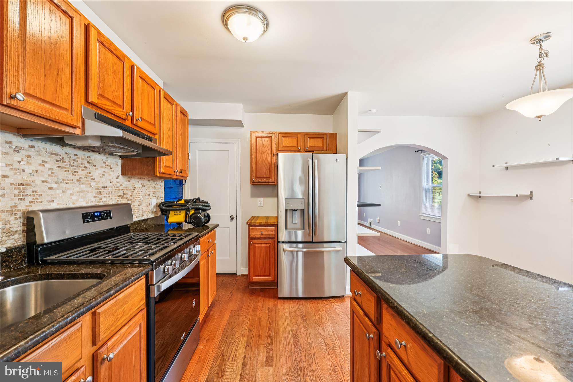 4808 Fort Totten Drive Northeast Washington, DC 20011 - Photo 8 of 30 a kitchen with stainless steel appliances granite countertop a refrigerator a stove and a sink with wooden floor