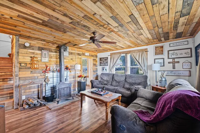 a living room with furniture a wooden floor and next to a large window