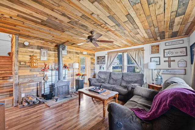 a living room with furniture a wooden floor and next to a large window