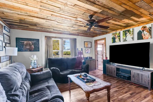 a living room with furniture a flat screen tv and a table