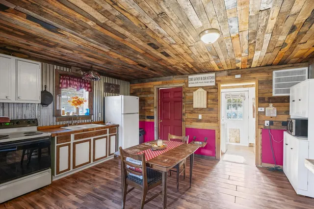 a kitchen with stainless steel appliances granite countertop a stove a sink dishwasher and cabinets with wooden floor