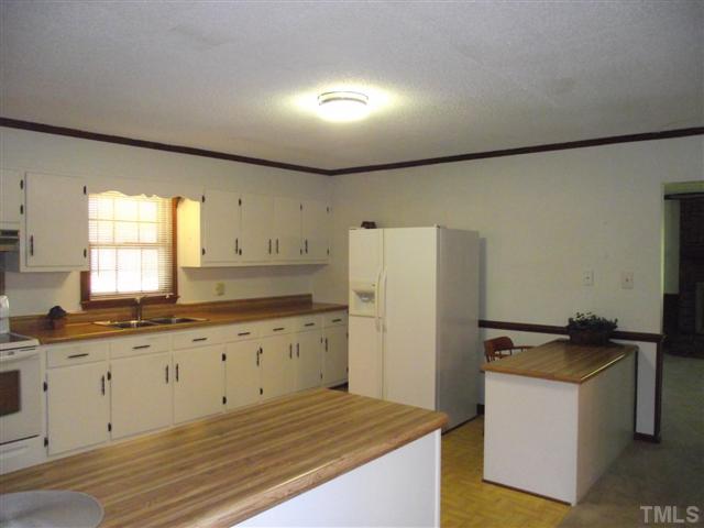 2661 Alderman Mill Road Dunn, NC 28334 - Photo 8 of 25 a kitchen with granite countertop cabinets a sink and a refrigerator