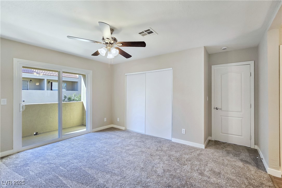 1812 North Decatur Boulevard, Unit 202 Las Vegas, NV 89108 - Photo 11 of 22 Primary Suite features a Ceiling Fan, New Sliding Glass Door to Balcony, and Bathroom with Dual Sinks, Tub/Shower Combination, and LVP Flooring