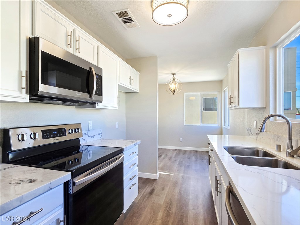 1812 North Decatur Boulevard, Unit 202 Las Vegas, NV 89108 - Photo 3 of 22 Updated Kitchen boasts Granite Counters, White Cabinets, and Stainless-Steel Electric Stove, Dishwasher, and Microwave
