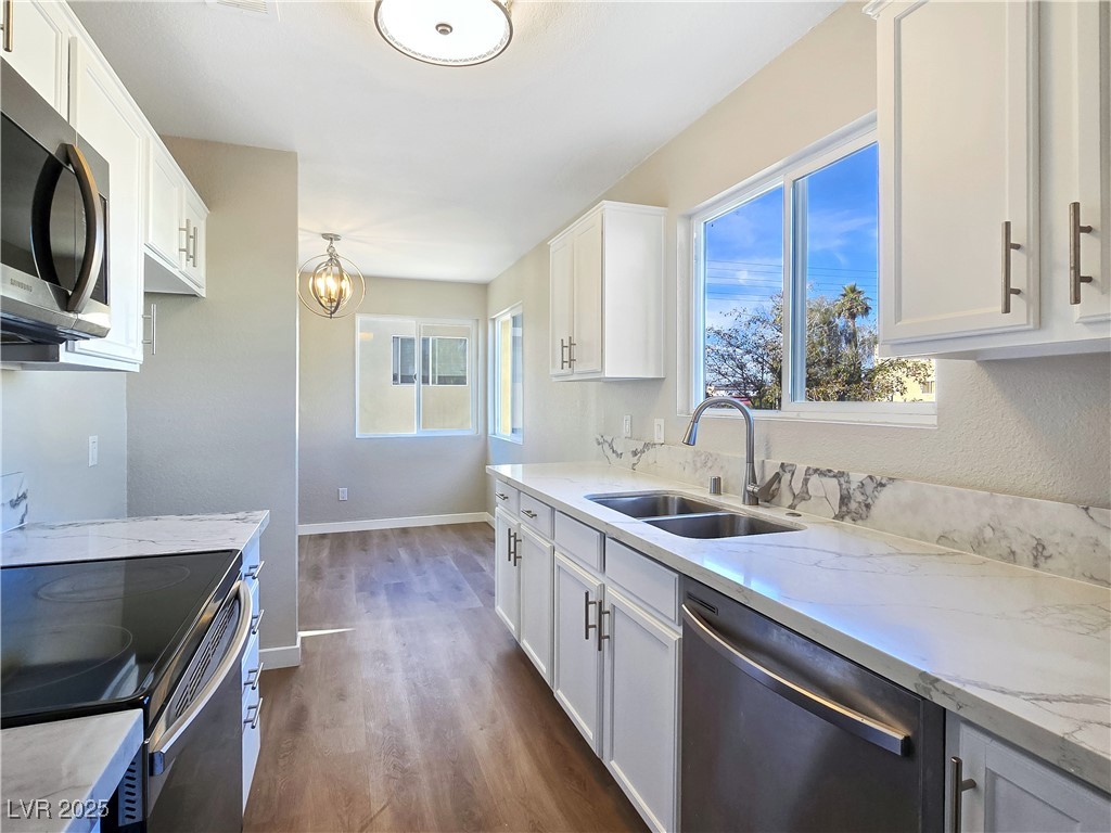 1812 North Decatur Boulevard, Unit 202 Las Vegas, NV 89108 - Photo 4 of 22 Updated Kitchen boasts Granite Counters, White Cabinets, and Stainless-Steel Electric Stove, Dishwasher, and Microwave