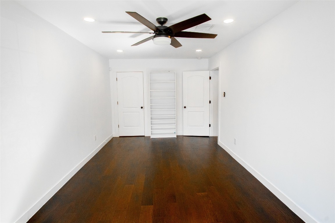 4423 Coyle Street Houston, TX 77023 - Photo 9 of 26 an empty room with a ceiling fan and wooden floor