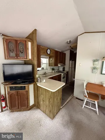 a kitchen with stainless steel appliances a stove a refrigerator a sink a oven with a dining table and chairs