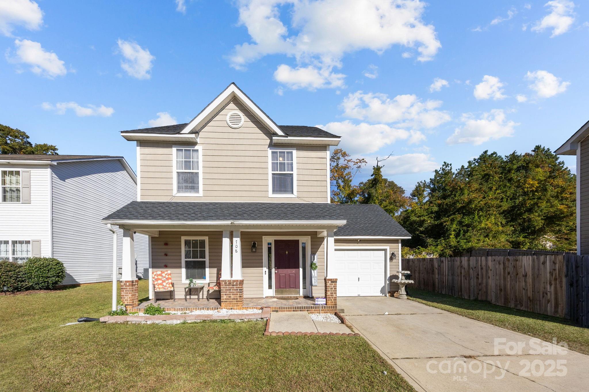 a front view of a house with a yard outdoor seating and garage