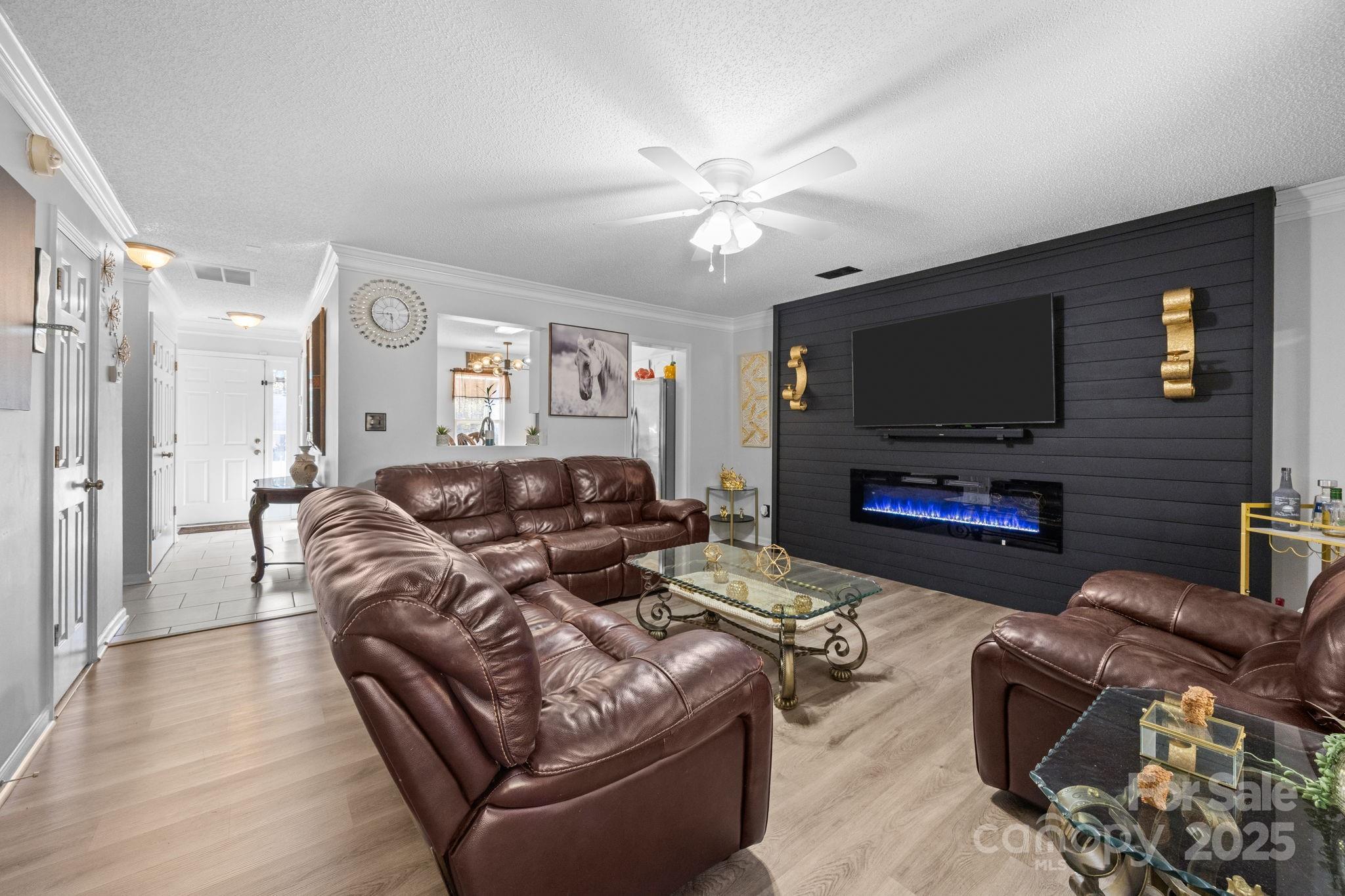 708 Raindrops Road Gastonia, NC 28054 - Photo 2 of 28 a living room with furniture a flat screen tv and a fireplace