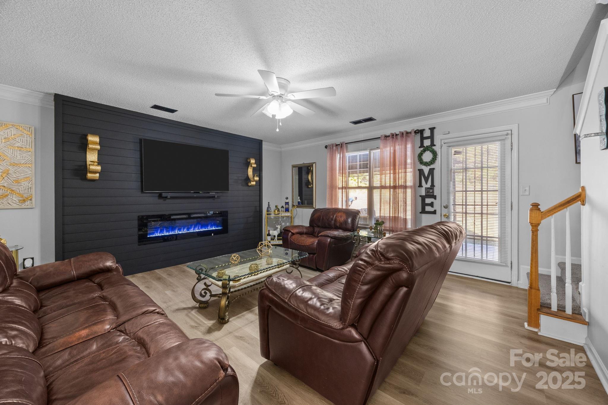 708 Raindrops Road Gastonia, NC 28054 - Photo 3 of 28 a living room with furniture a flat screen tv and a fireplace