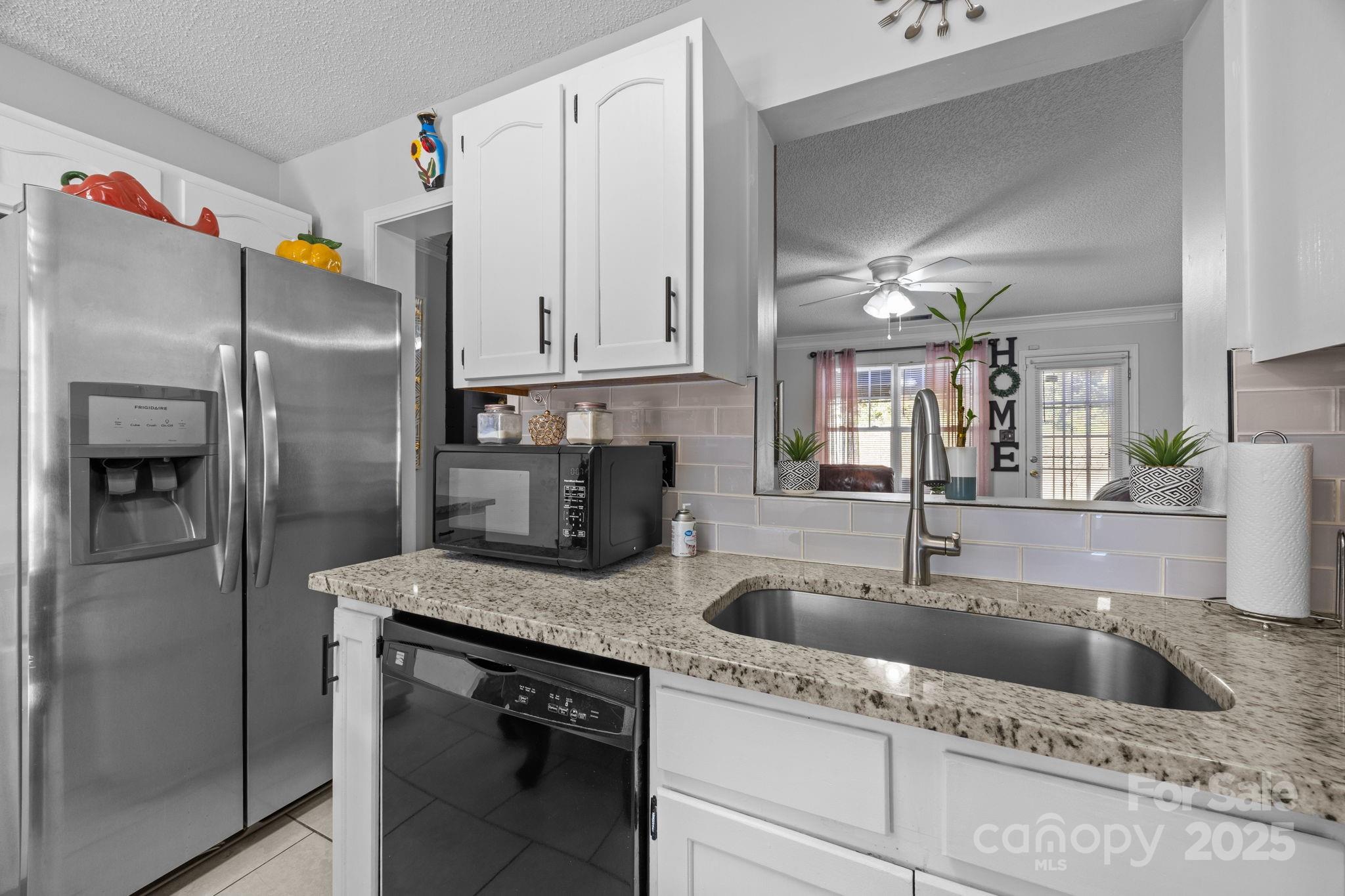 708 Raindrops Road Gastonia, NC 28054 - Photo 7 of 28 a kitchen with stainless steel appliances granite countertop a refrigerator a sink and white cabinets