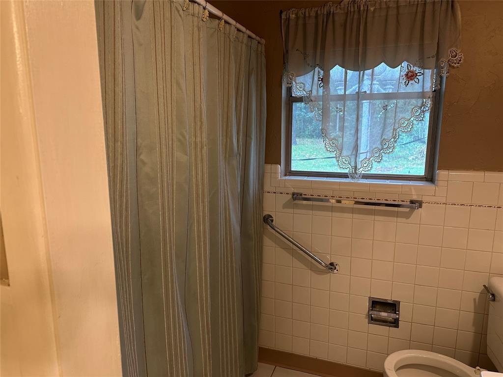 532 Plainview Drive Hurst, TX 76054 - Photo 34 of 40 a bathroom with a toilet and a shower curtain