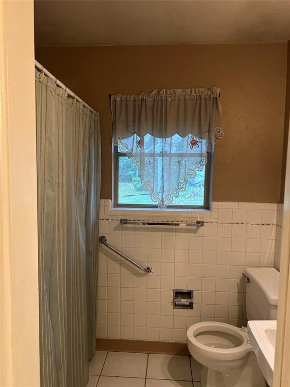 532 Plainview Drive Hurst, TX 76054 - Photo 35 of 40 a bathroom with a toilet and a shower curtain