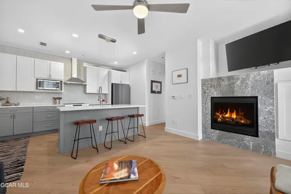 a open kitchen with a sink a fireplace and chairs