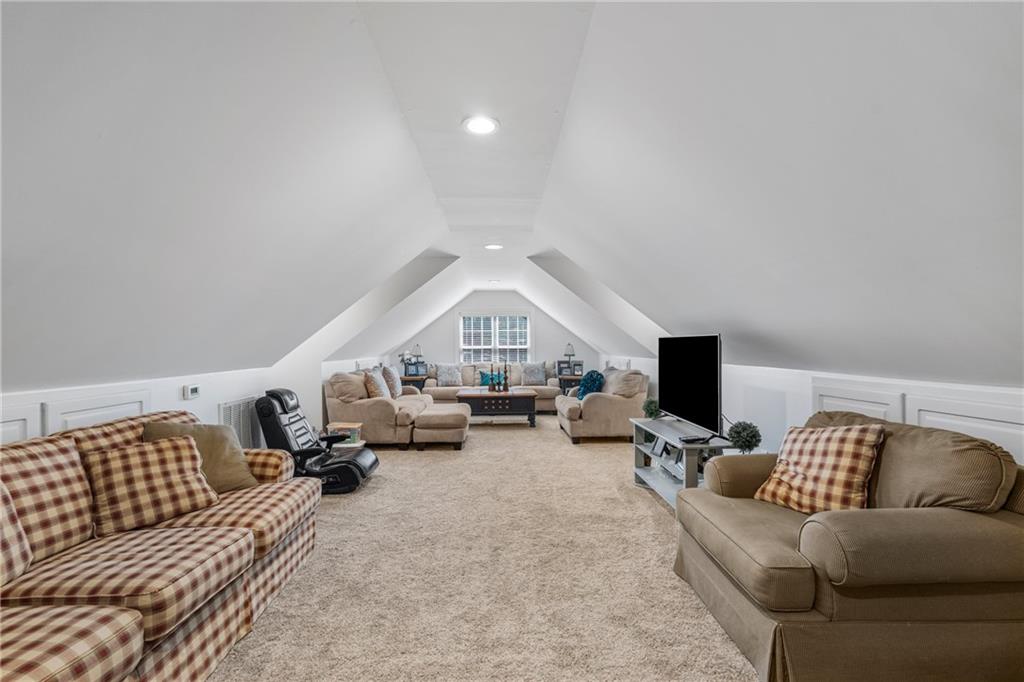 642 Nuckols Road Seale, AL 36875 - Photo 37 of 48 Spacious bonus room featuring vaulted ceilings, recessed lighting, carpet flooring, and wainscoting detailing