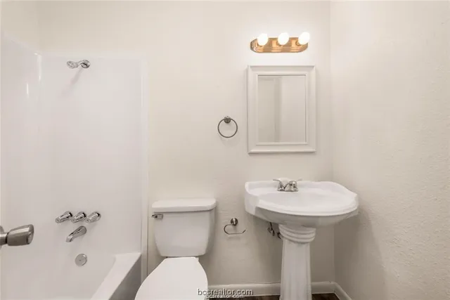 a bathroom with a sink toilet and a mirror