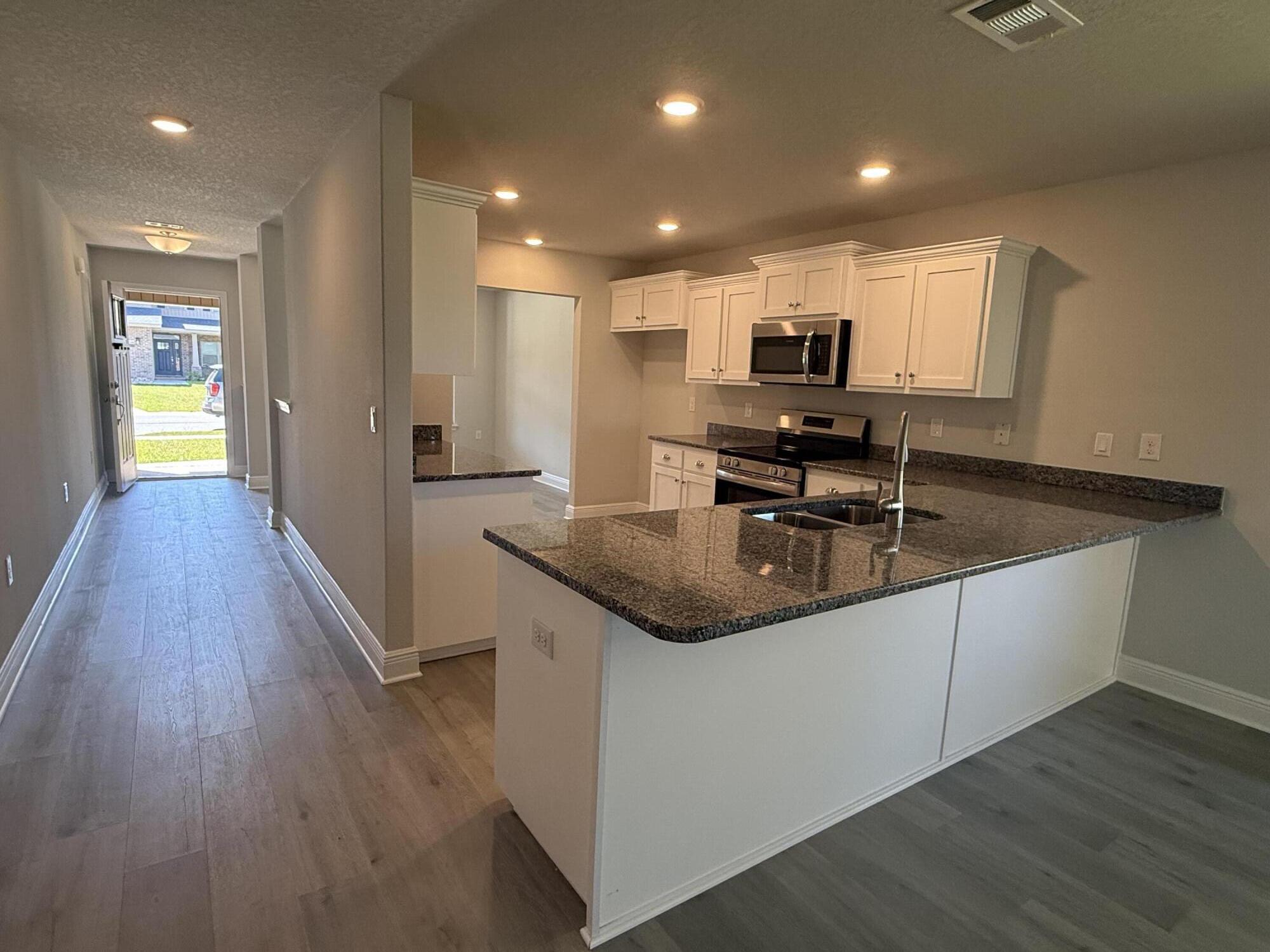 183 Ridgeway Circle Crestview, FL 32536 - Photo 15 of 28 a kitchen with stainless steel appliances granite countertop a sink a stove and wooden floor