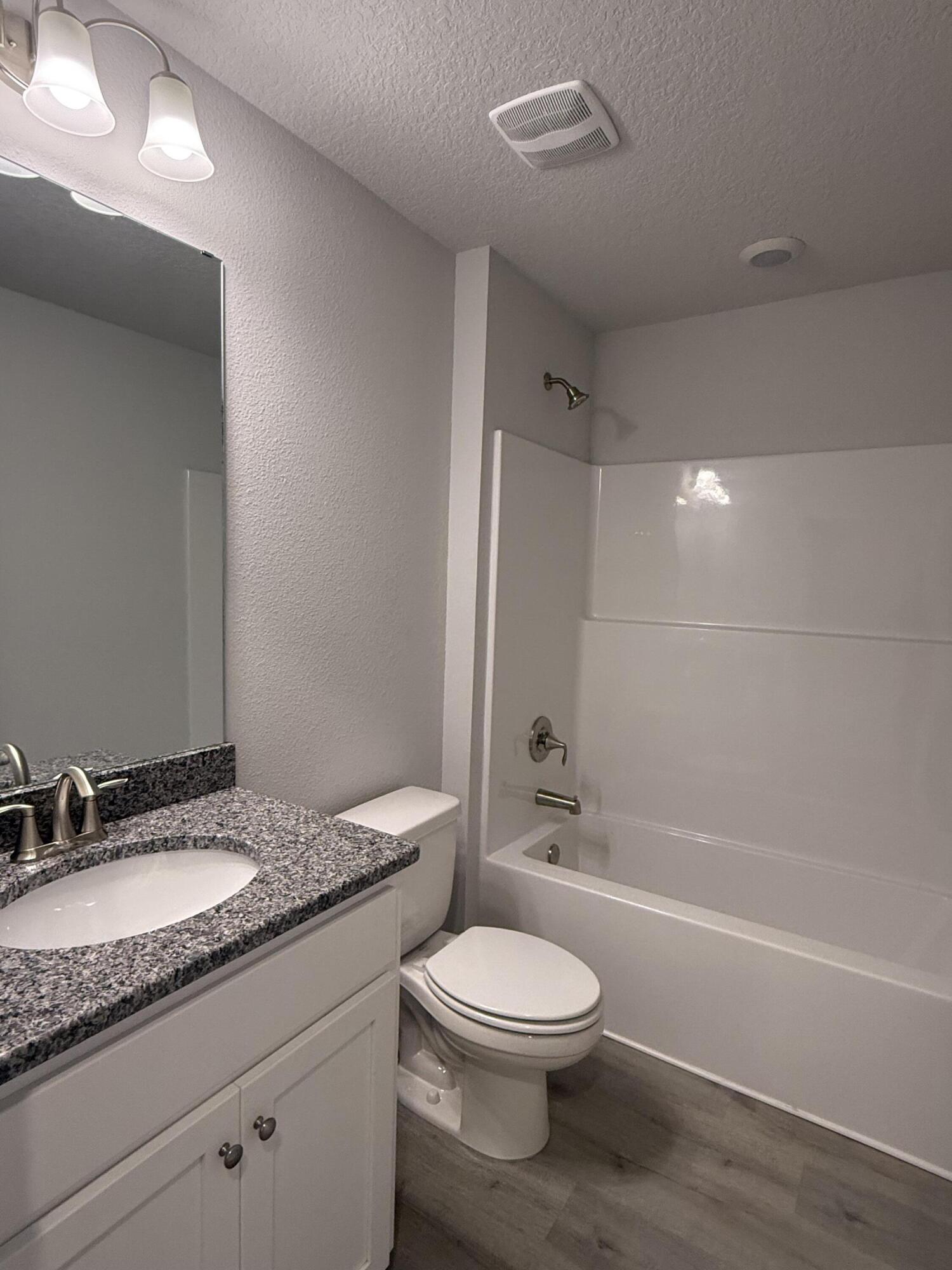 183 Ridgeway Circle Crestview, FL 32536 - Photo 19 of 28 a bathroom with a granite countertop toilet a sink and a bathtub