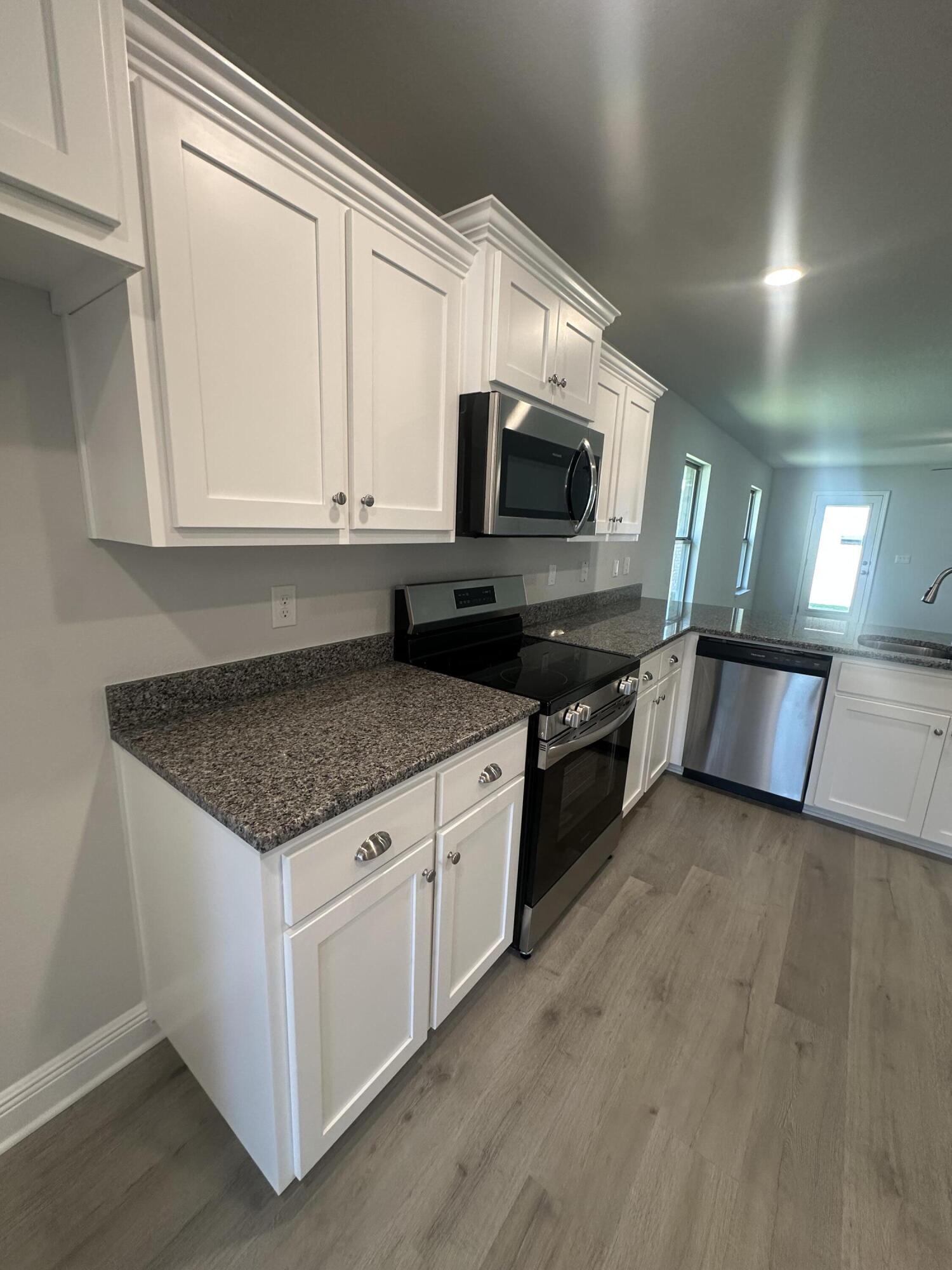 183 Ridgeway Circle Crestview, FL 32536 - Photo 7 of 28 a kitchen with stainless steel appliances granite countertop a stove a microwave and a sink