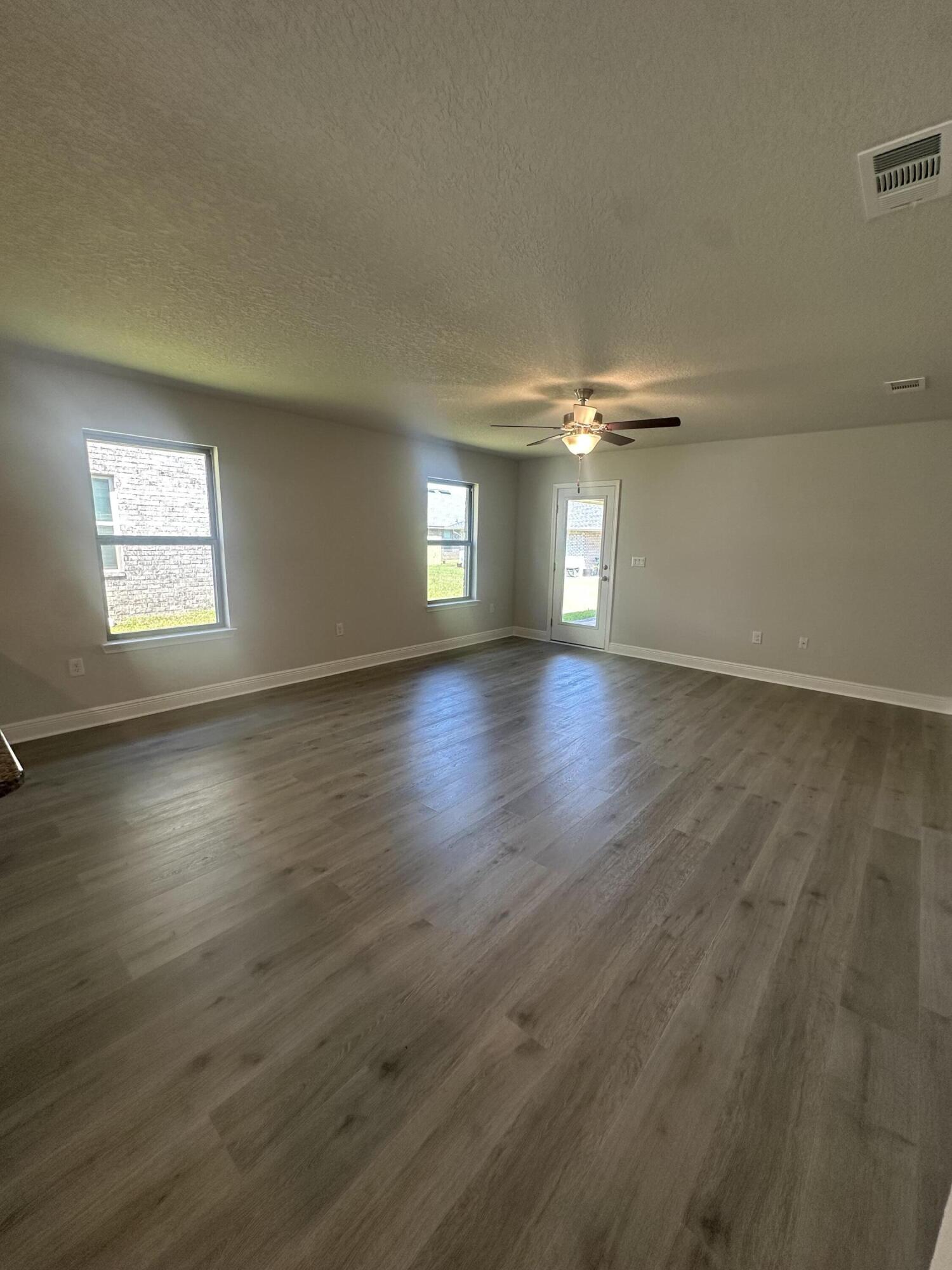 183 Ridgeway Circle Crestview, FL 32536 - Photo 9 of 28 an empty room with wooden floor and windows