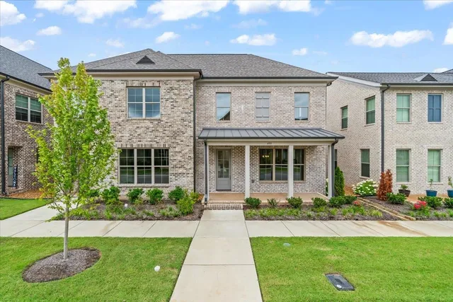 a front view of a house with a yard and potted plants