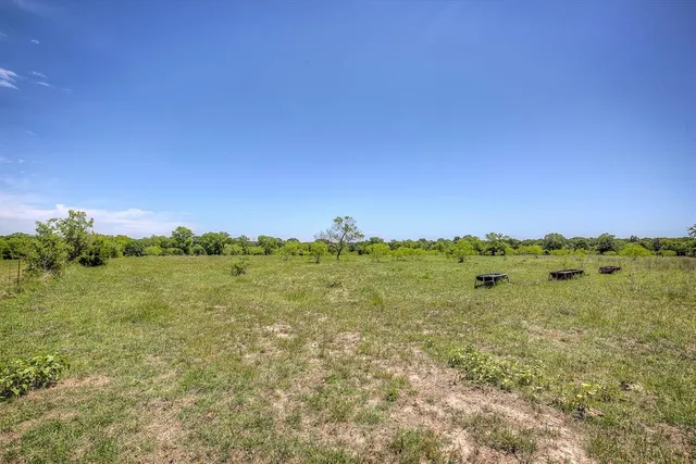 a view of a green field with mountains in the background
