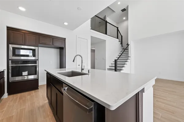 a kitchen with stainless steel appliances a sink and a refrigerator
