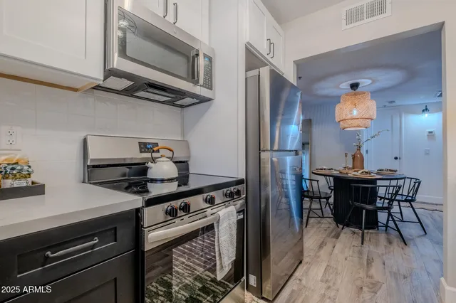 a kitchen with stainless steel appliances granite countertop a stove and a wooden cabinets